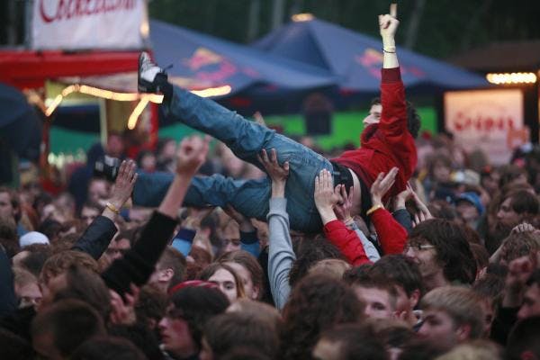 Person crowdsurft über die Menge vor der Bühne, wird von vielen Händen gehalten